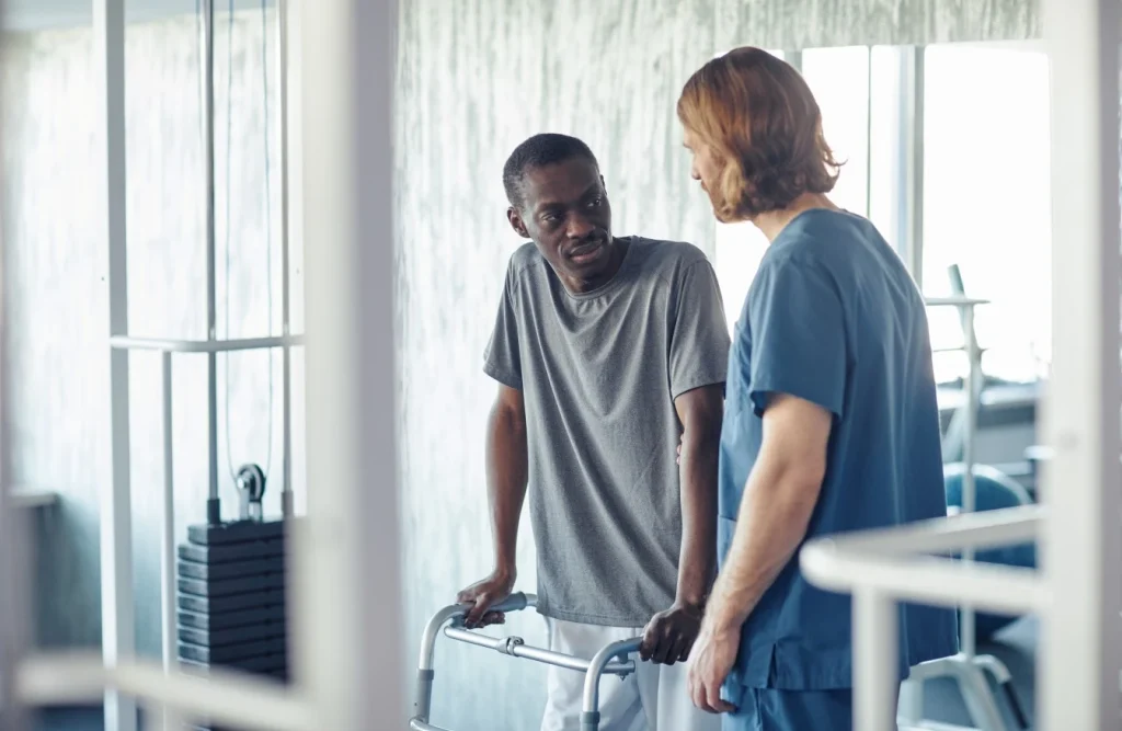 Disabled man with walker talking with nurse