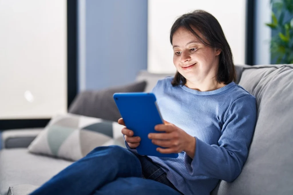 Happy woman with down syndrome using tablet