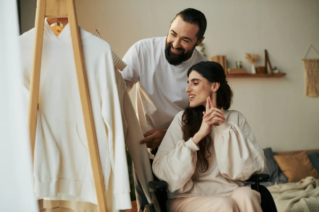 Disabled woman in wheelchair with support worker picking out clothes